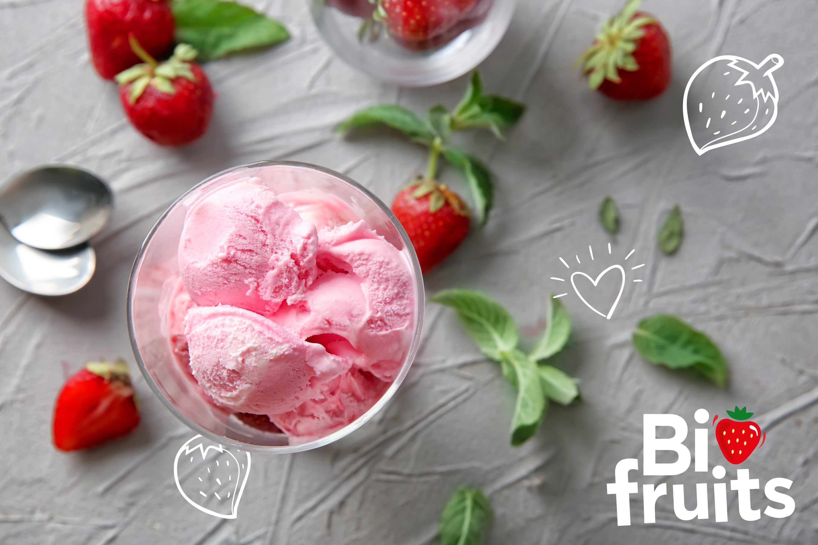 Une glace aux fraise Biofruits - Une image de boule de glace à la fraise avec des fraises fraîches à côté