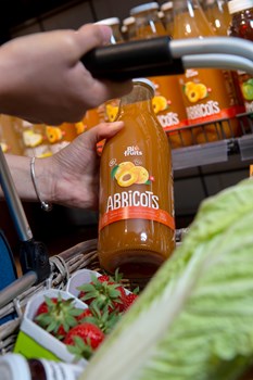 Les jus au Shop de Vétroz - Une personne mettant dans son panier un nectar d'abricots