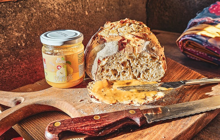 Pain au levain avec une confiture Biofruits à la poire Williams - Biofruits - Un pain sorti du four, avec une tranche découpée et de la confiture à la poire Williams tartinée dessus