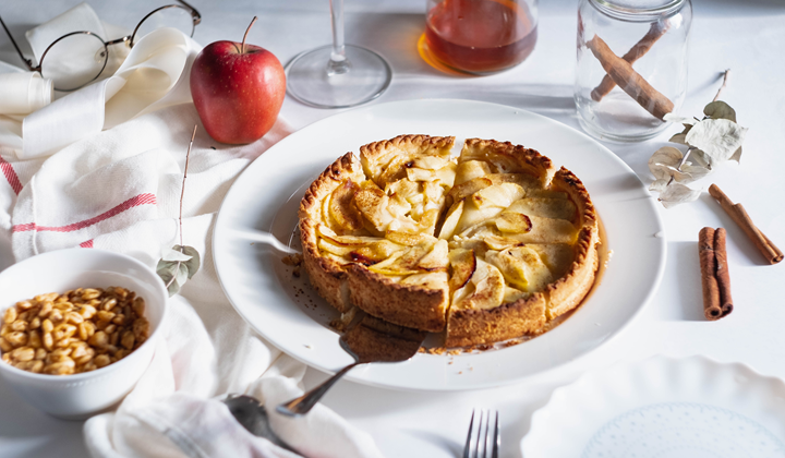 Tarte aux pommes Biofruits - Une photo d'une tarte aux pommes sur une table avec une nappe blanche et avec des ingrédients partout